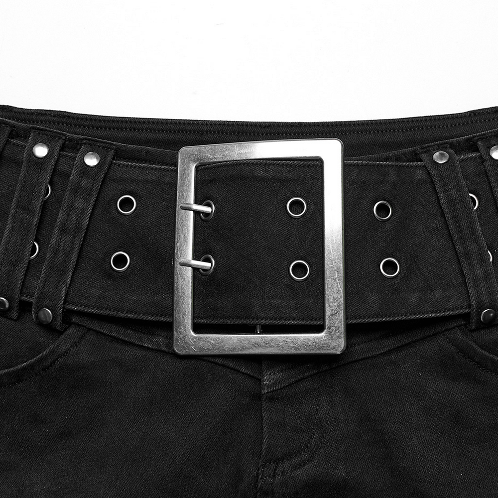 Close-up of black denim shorts featuring a metal buckle and studded belt for a punk aesthetic.