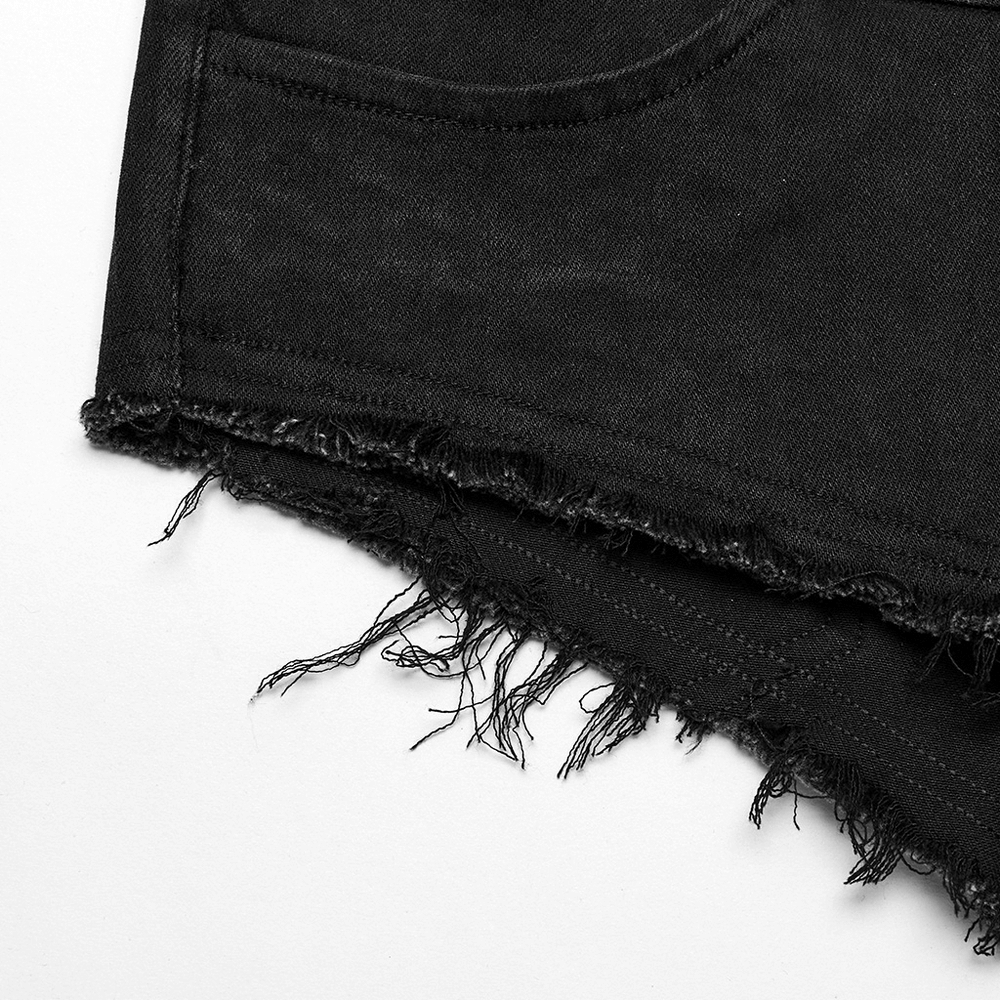 Close-up of edgy black denim shorts with frayed hem, showcasing punk style and rebellious design.