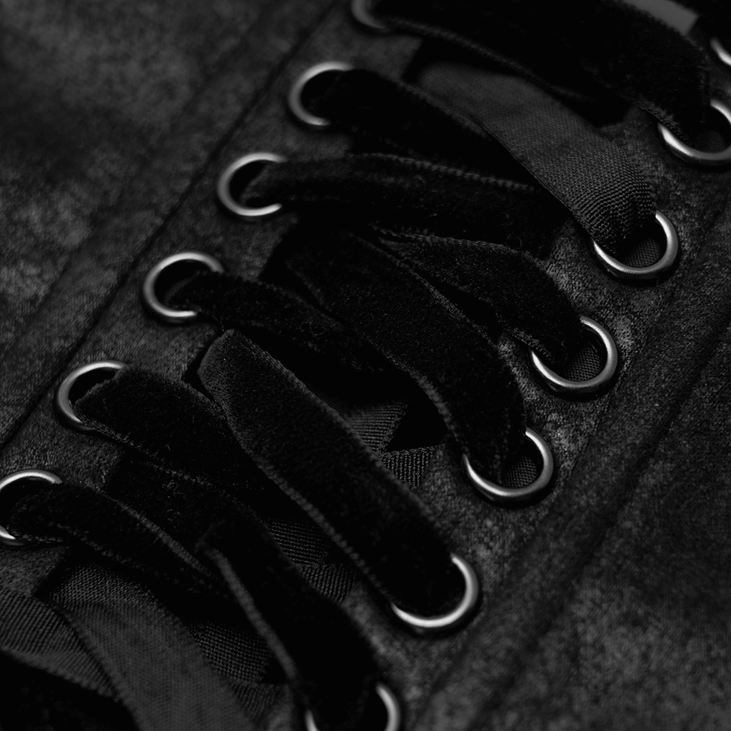 Close-up of lace-up details on a black gothic corset belt featuring eyelets and satin laces.
