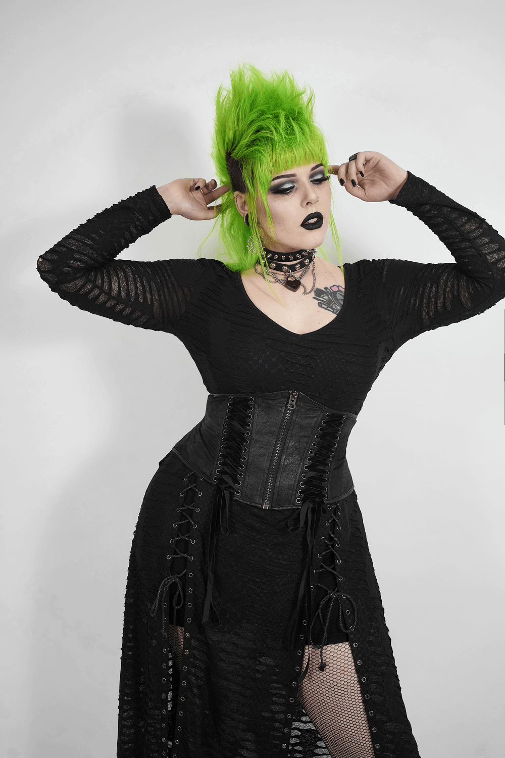 Model showcasing an edgy black gothic corset belt with lace-up details and vibrant green hair.
