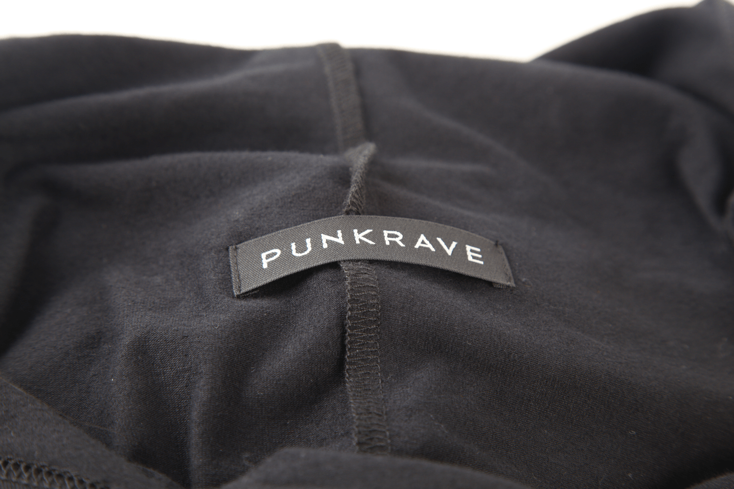 Close-up of the PUNKRAVE label on a black hooded top, showcasing trendy fashion details.