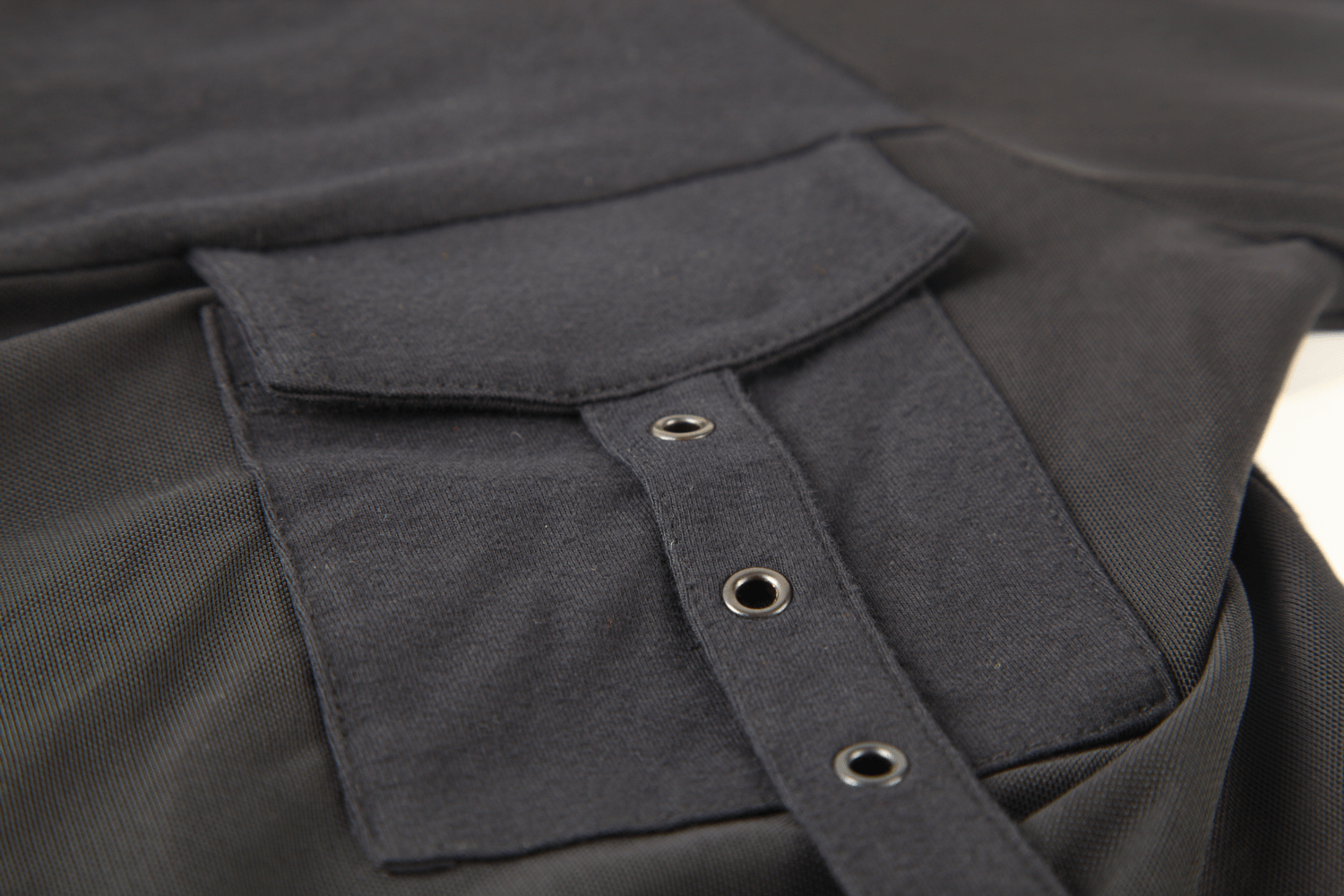 Close-up of a chic black hooded top showcasing its stylish mesh sleeves and corset detailing.