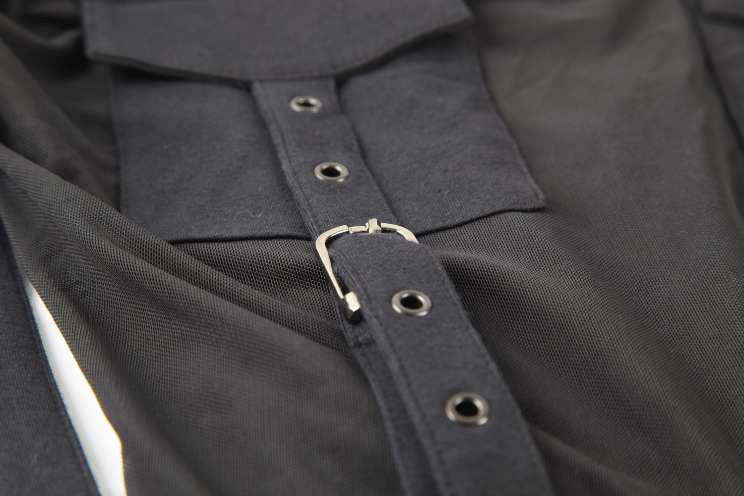 Close-up of black hooded top with stylish corset detailing and buttons, showcasing chic mesh sleeves.