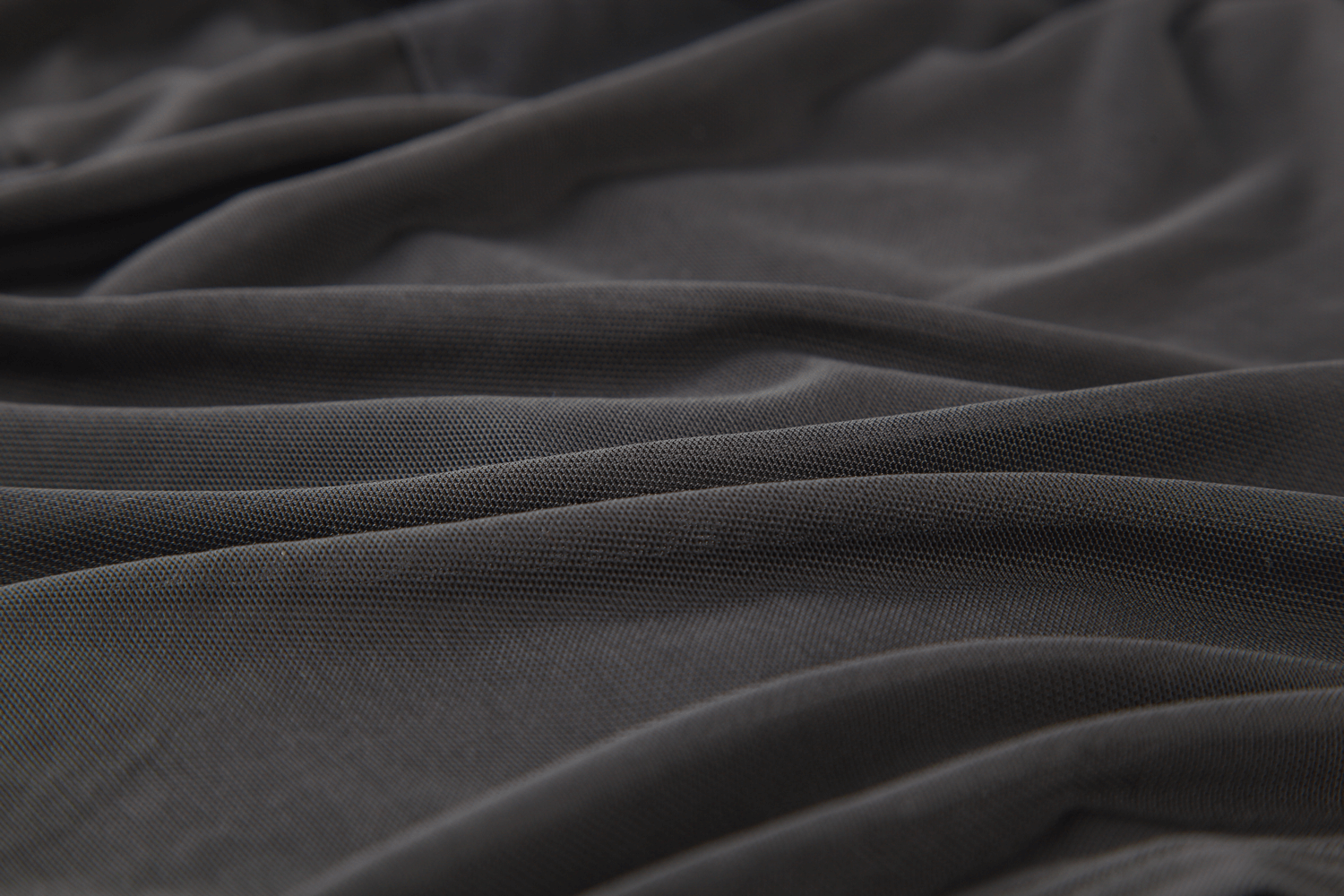 Close-up of soft black fabric, showcasing the elegant texture and mesh detailing perfect for edgy apparel.