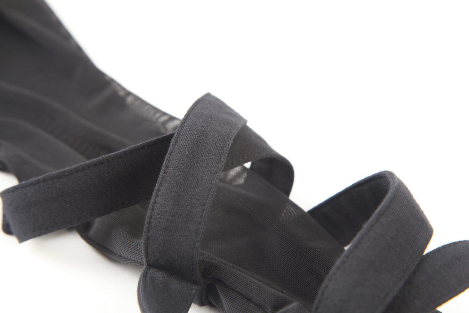Close-up of black mesh fabric with elegant straps, showcasing modern fashion details for stylish apparel.