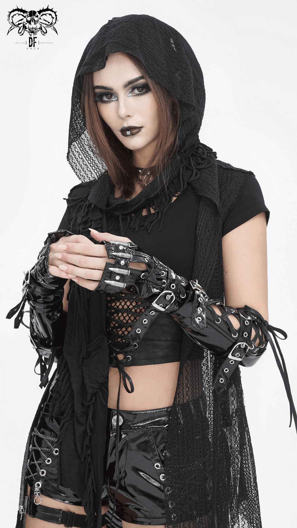 Gothic model wearing edgy black lace-up fingerless gloves and a hooded top, showcasing a striking dark fashion style.
