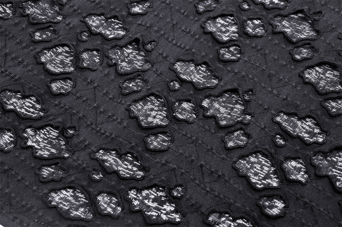 Close-up of textured black fabric with silver patterns, ideal for edgy and alternative fashion.