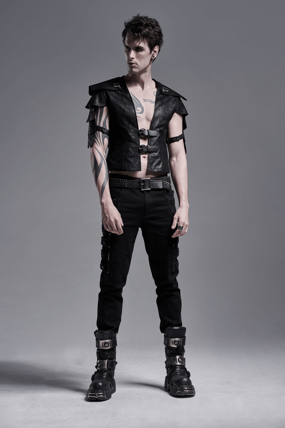 Edgy black leather vest with adjustable straps worn by a model, showcasing a stylish punk-rock look.