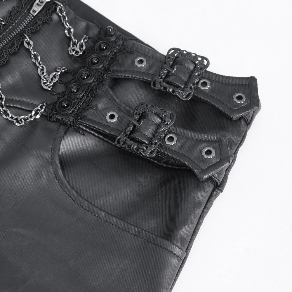 Close-up of edgy black zippered pants with buckles and lace-up detail, featuring chains and studded waistband.