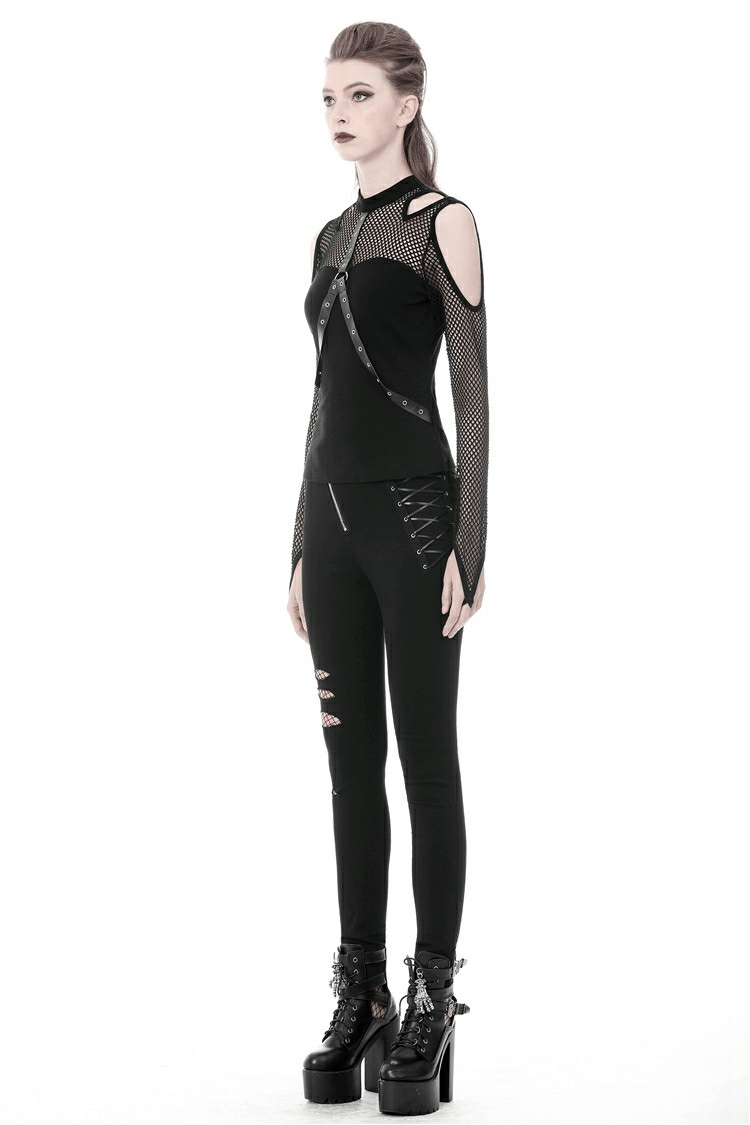 Edgy black mesh cold shoulder top with stylish studs, paired with sleek black leggings and platform boots.