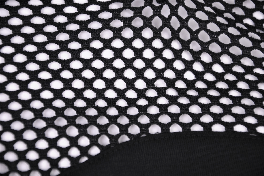 Close-up of black mesh fabric with white backing, showcasing a unique pattern for an edgy gothic style top.