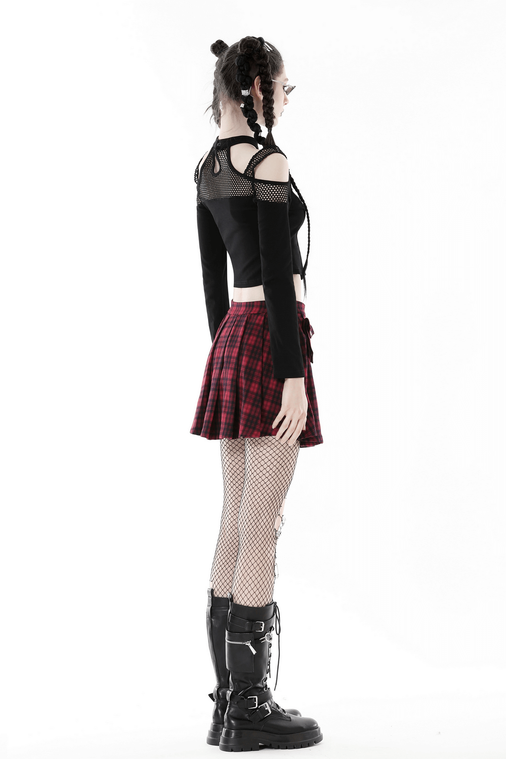 Edgy black mesh off-shoulder top with long sleeves paired with a red plaid skirt and fishnet stockings.