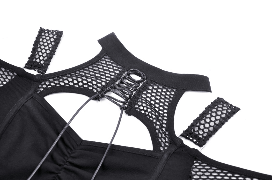 Detail of edgy black mesh off-shoulder top showcasing fishnet fabric and cross design.
