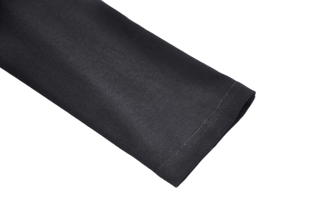 Close-up of a black long sleeve from an edgy off-shoulder fishnet top, showcasing soft fabric and bold style.