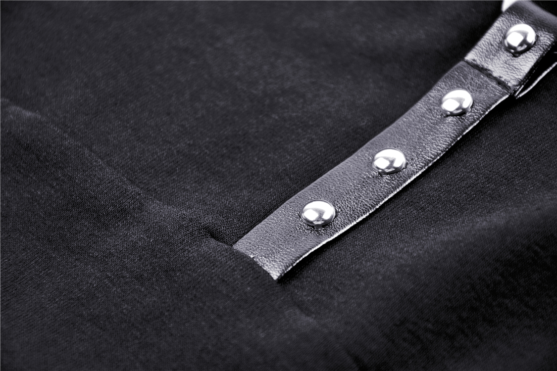 Close-up of edgy black crop top with strappy design and metallic stud details for bold fashion statement.