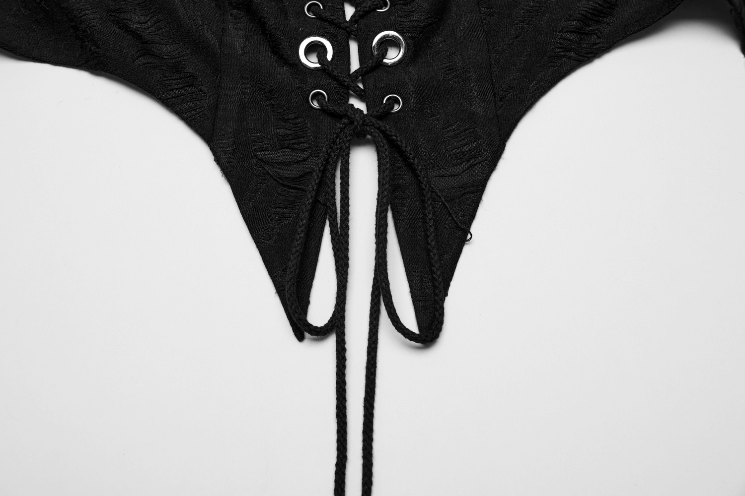 Close-up of an edgy black punk halter crop top with lace-up front detail and pointed hem.