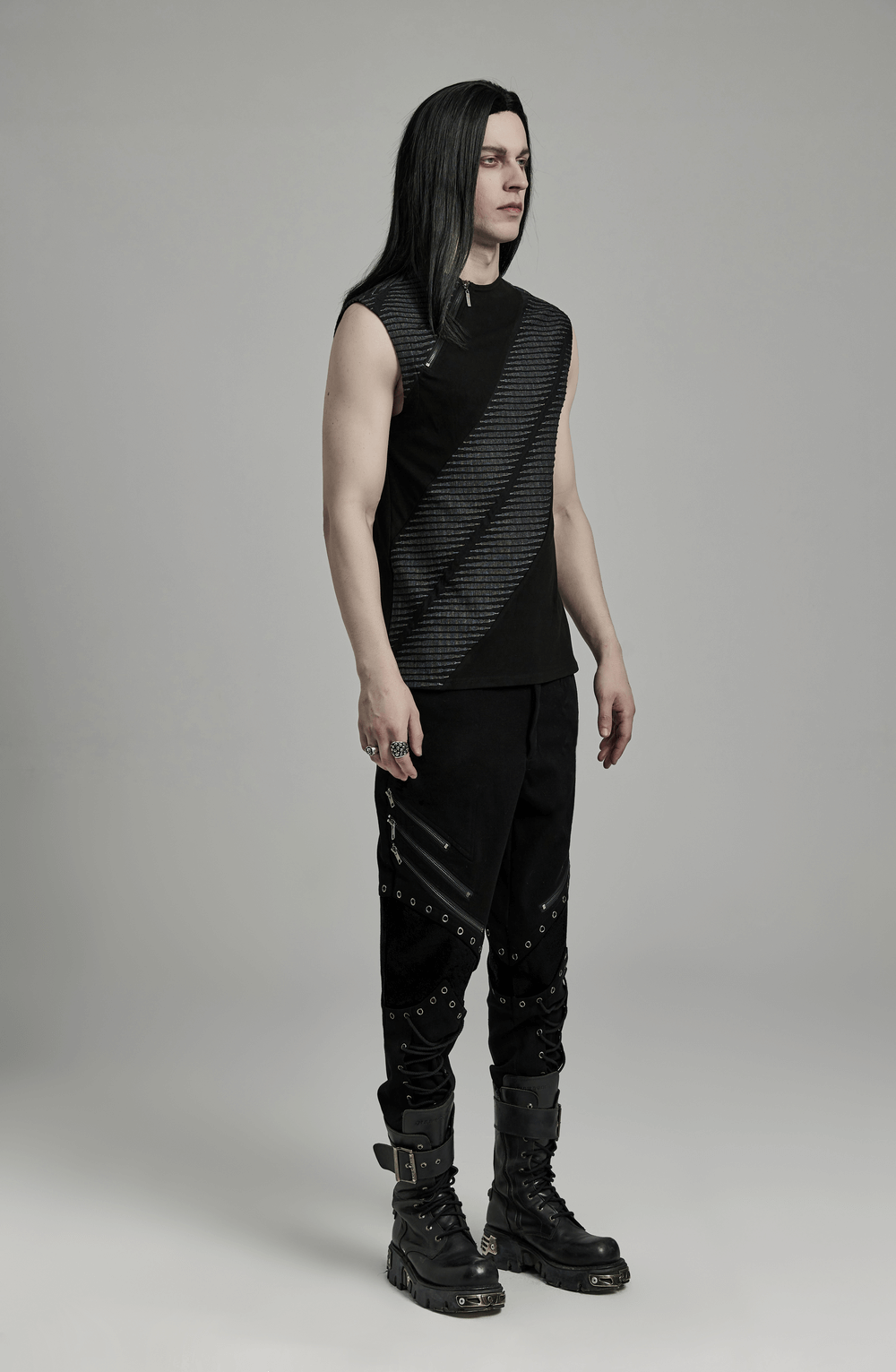 Edgy black sleeveless top with striped design, paired with stylish black pants and combat boots for a rebellious look.