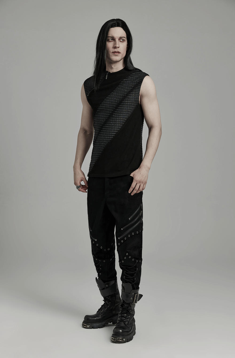 Model wearing an edgy black spliced top with zipper and black pants, showcasing a rebellious style.