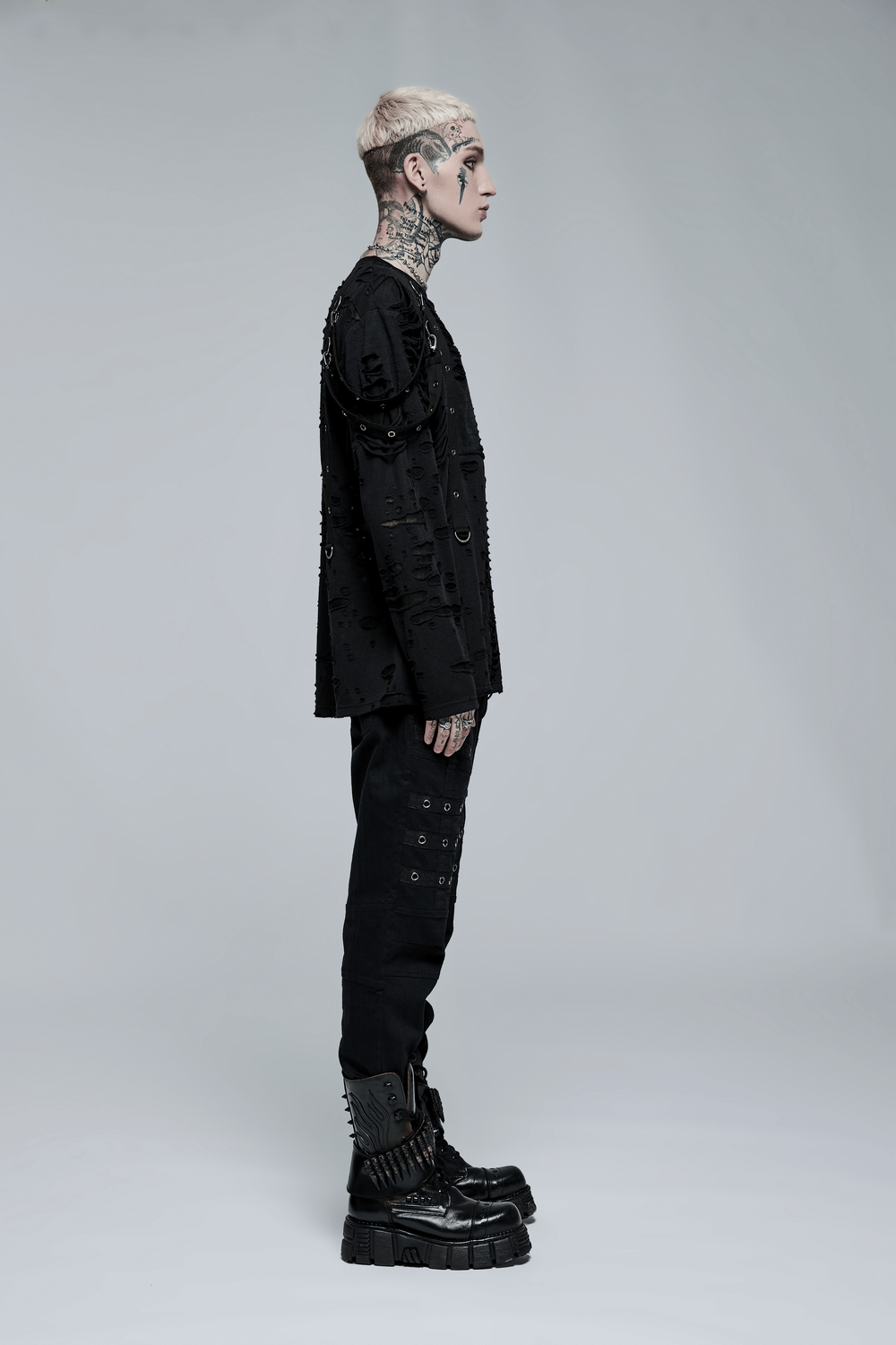 Stylish individual wearing edgy black cargo pants and patterned top, embodying punk goth streetwear vibe.