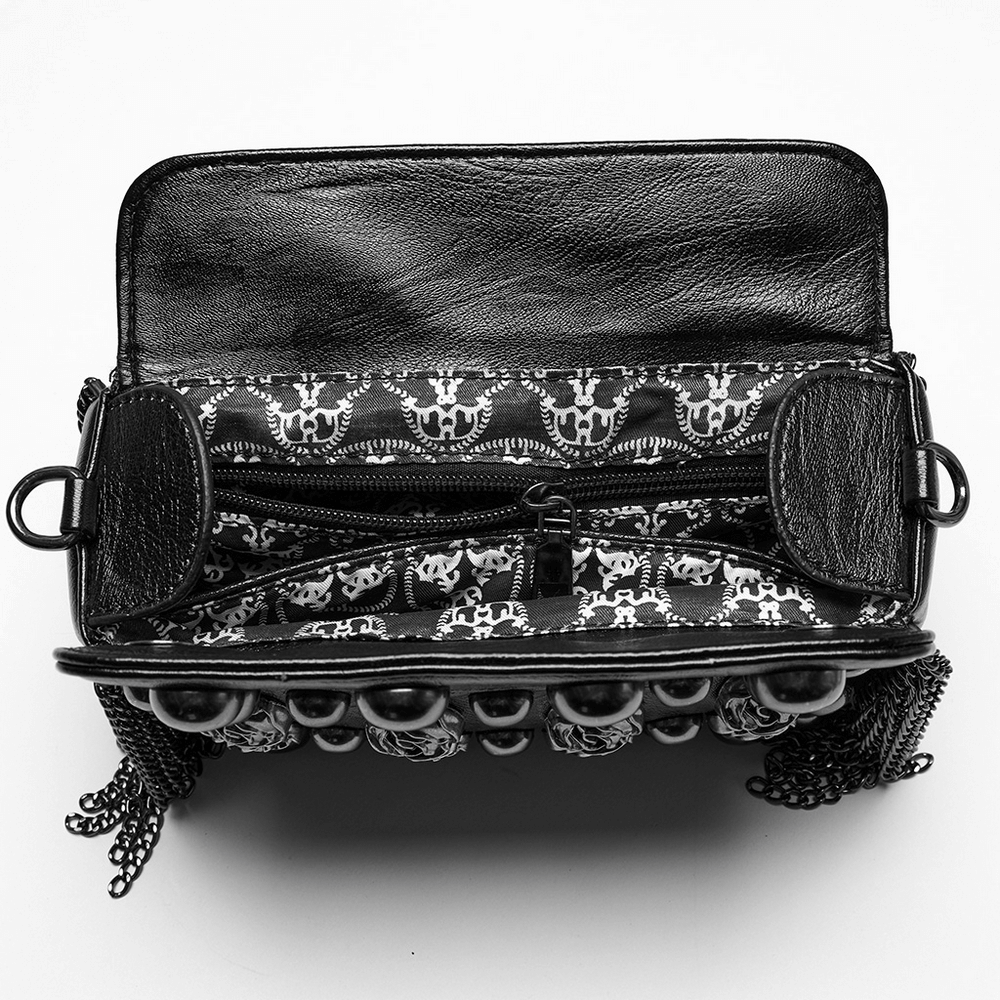 Interior view of edgy black studded crossbody bag featuring skull-patterned lining and spacious pockets for stylish storage.