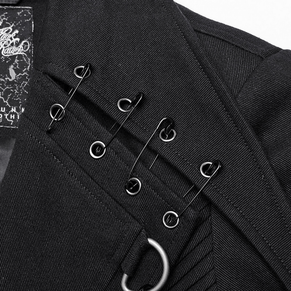 Close-up of edgy black trench coat with bold lapels and D-buckles showcasing unique pleating.