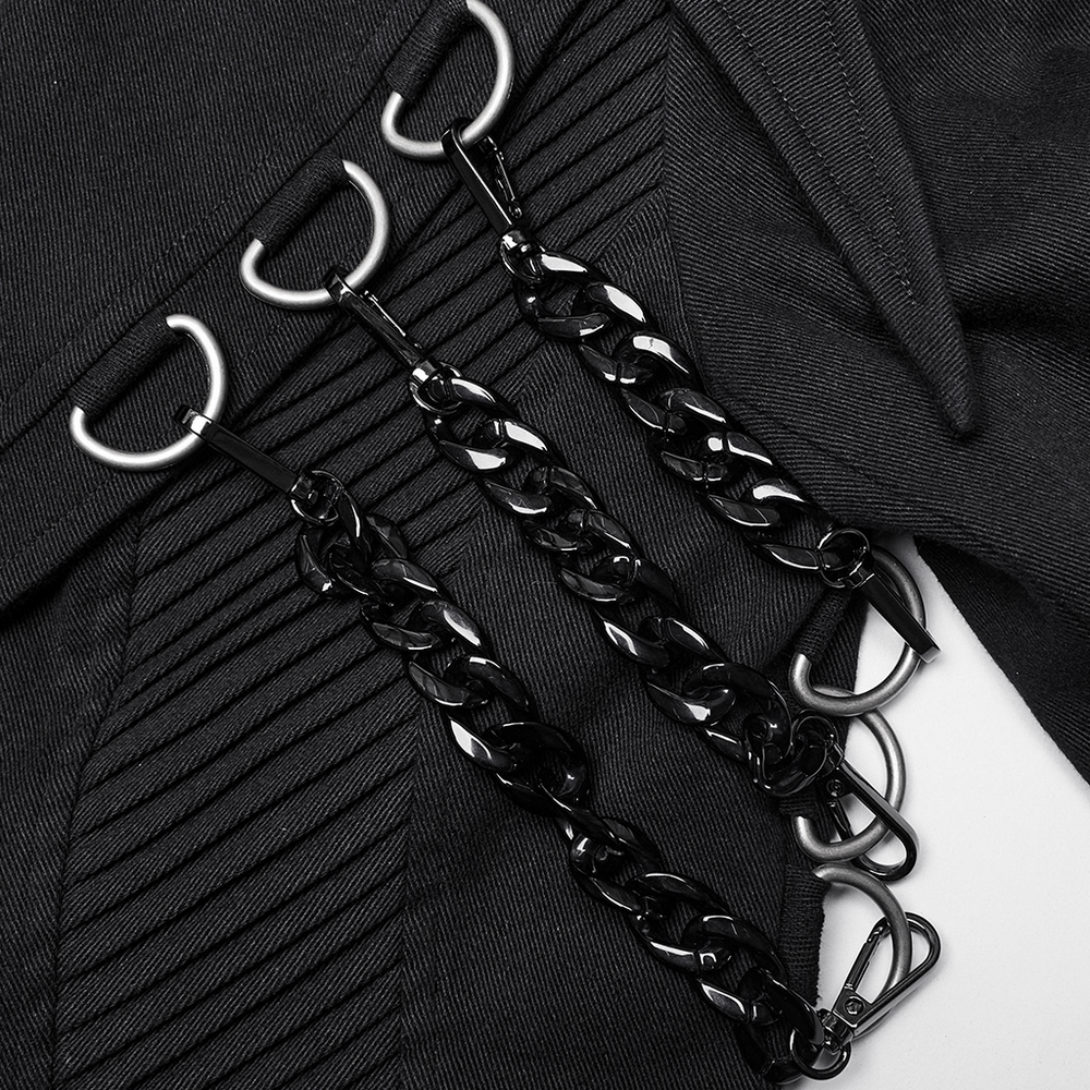 Close-up of edgy black D-buckles and chains on a trench coat, showcasing punk-inspired design details.