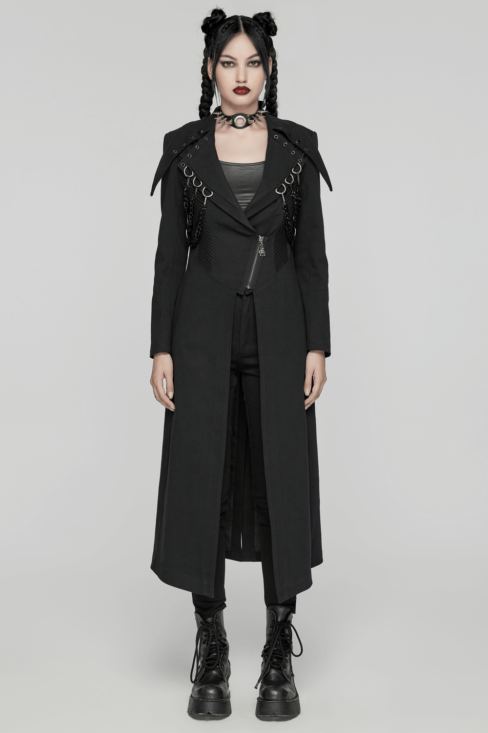 Edgy black trench coat with D-buckles and chains, punk style, bold lapels, and unique pleating for a striking look.