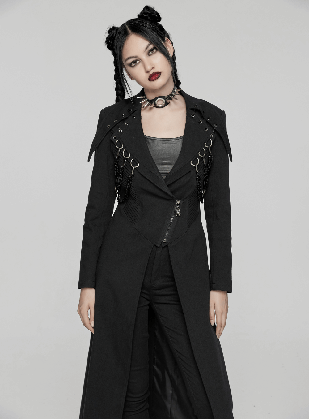 Edgy black trench coat with D-buckles, chains, and bold lapels for a punk-inspired style.