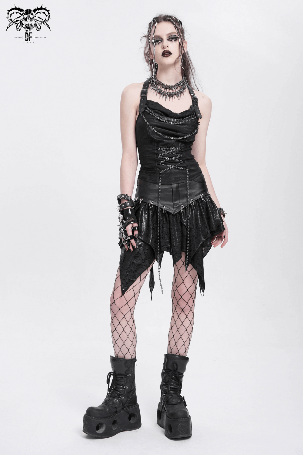 Edgy woman wearing a black dress with chains, fishnet tights, and chunky boots, showcasing gothic fashion vibes.
