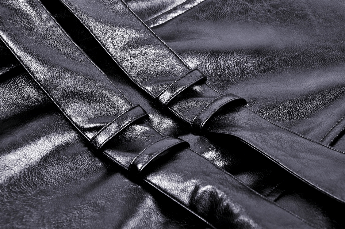 Close-up of stylish buckles on a sleek black faux leather dress, showcasing edgy fashion details.