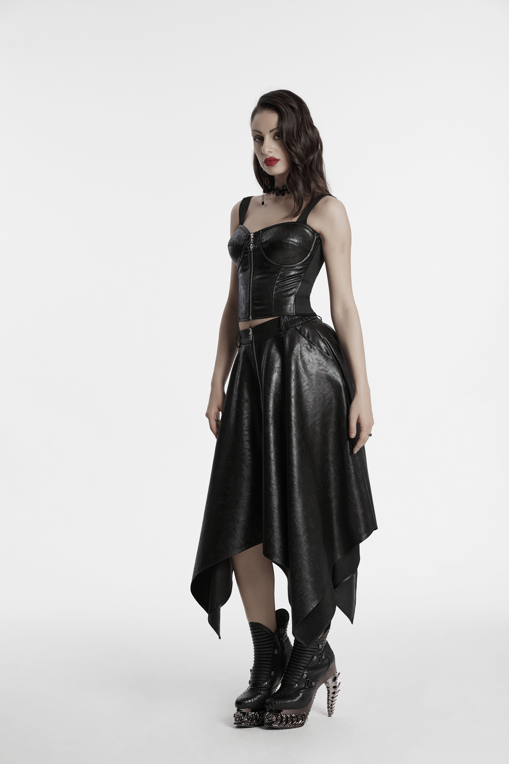 Edgy faux leather skirt with zipper and asymmetrical hem, paired with a stylish top and edgy boots on a model.