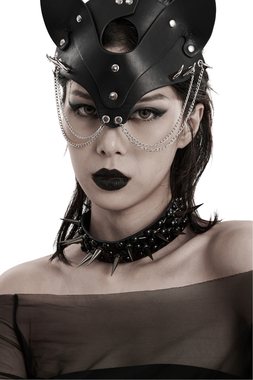 Punk aesthetic model wearing a spiked faux leather choker and edgy headpiece with chains.