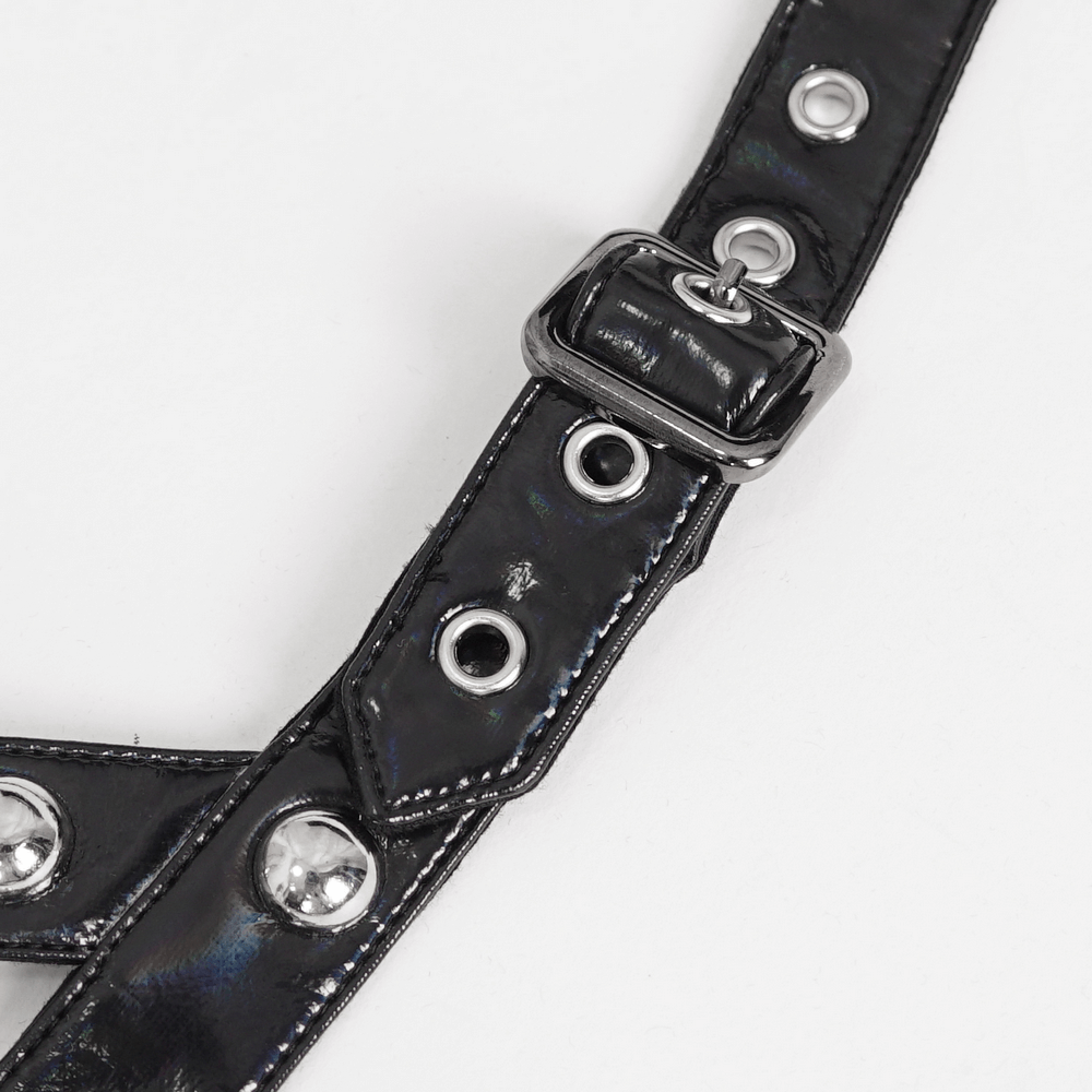 Close-up of a black studded harness strap with silver grommets and buckle, perfect for edgy fashion styling.