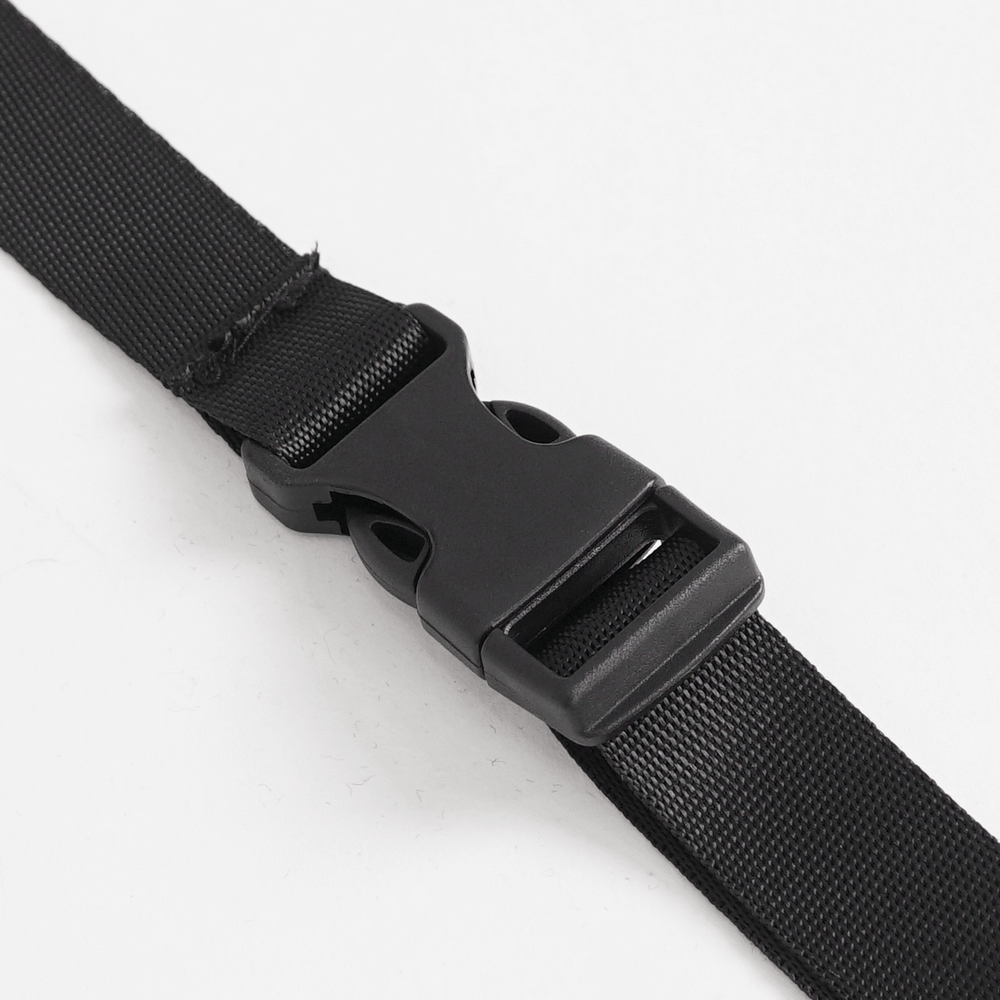Close-up of a black plastic buckle on a durable strap, perfect for adjustable clothing and accessories.