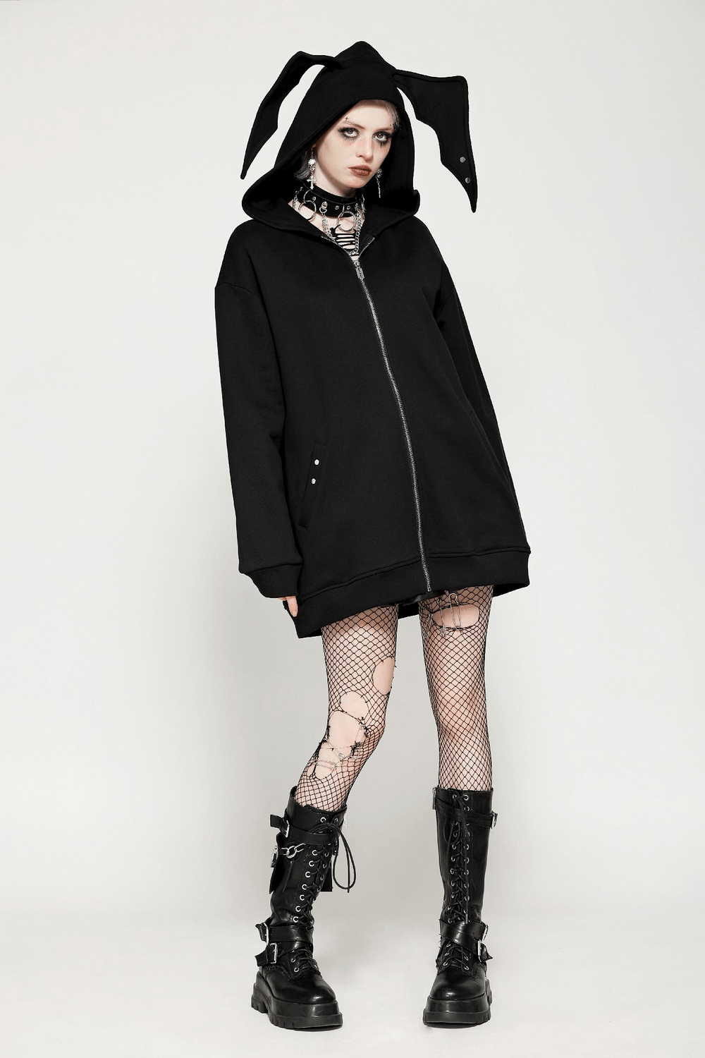 Edgy gothic batwing zip-up hoodie with bat ears, model wearing oversized batwing design and fishnet tights.