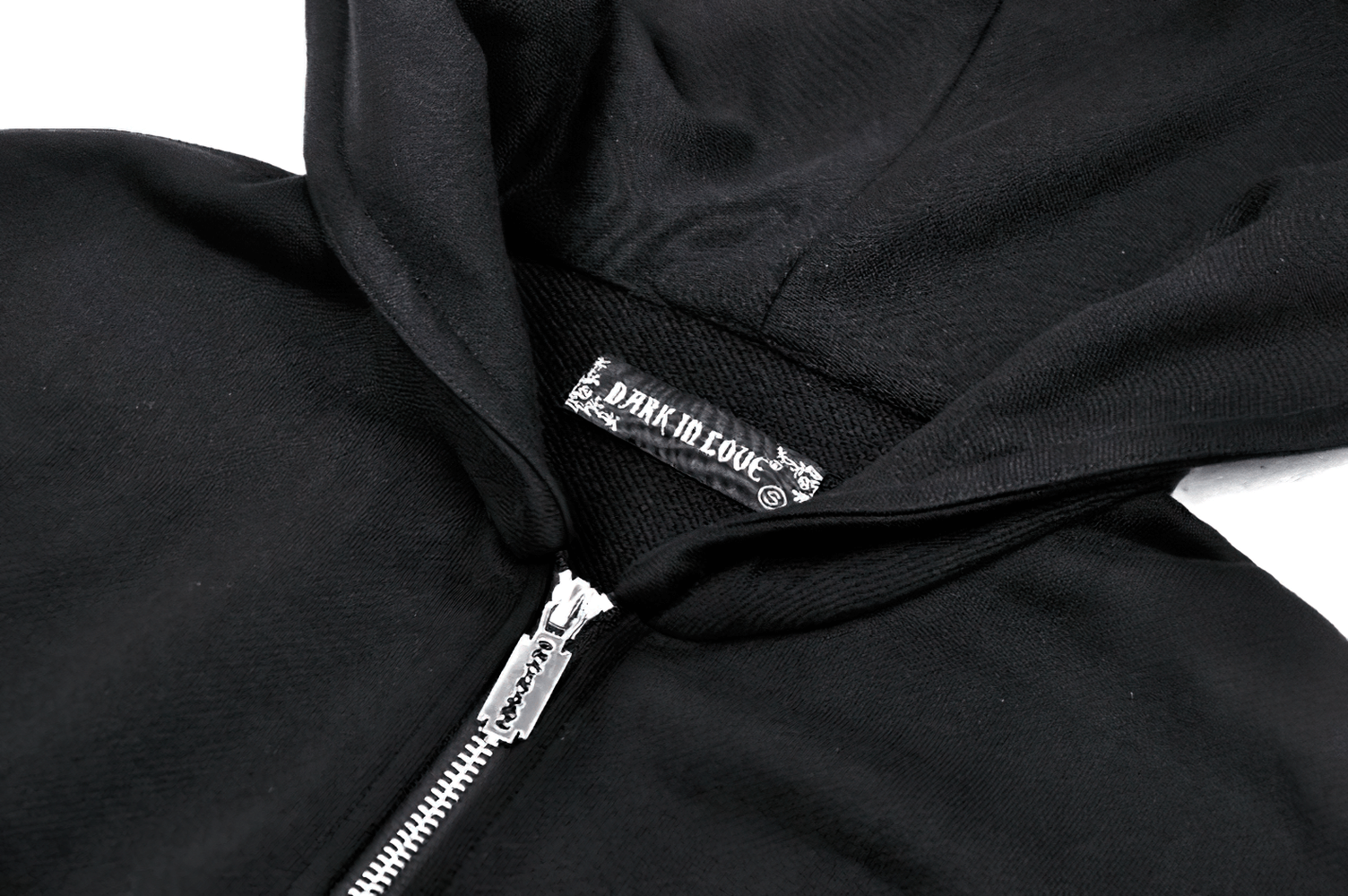 Close-up of black batwing zip-up hoodie featuring unique hood design and trendy gothic branding.