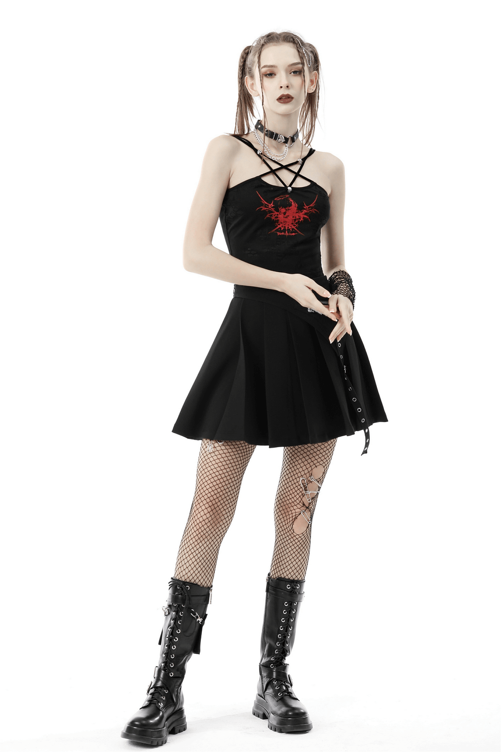 Edgy gothic black crop top with red print, strappy back, paired with a black skirt and fishnet tights.