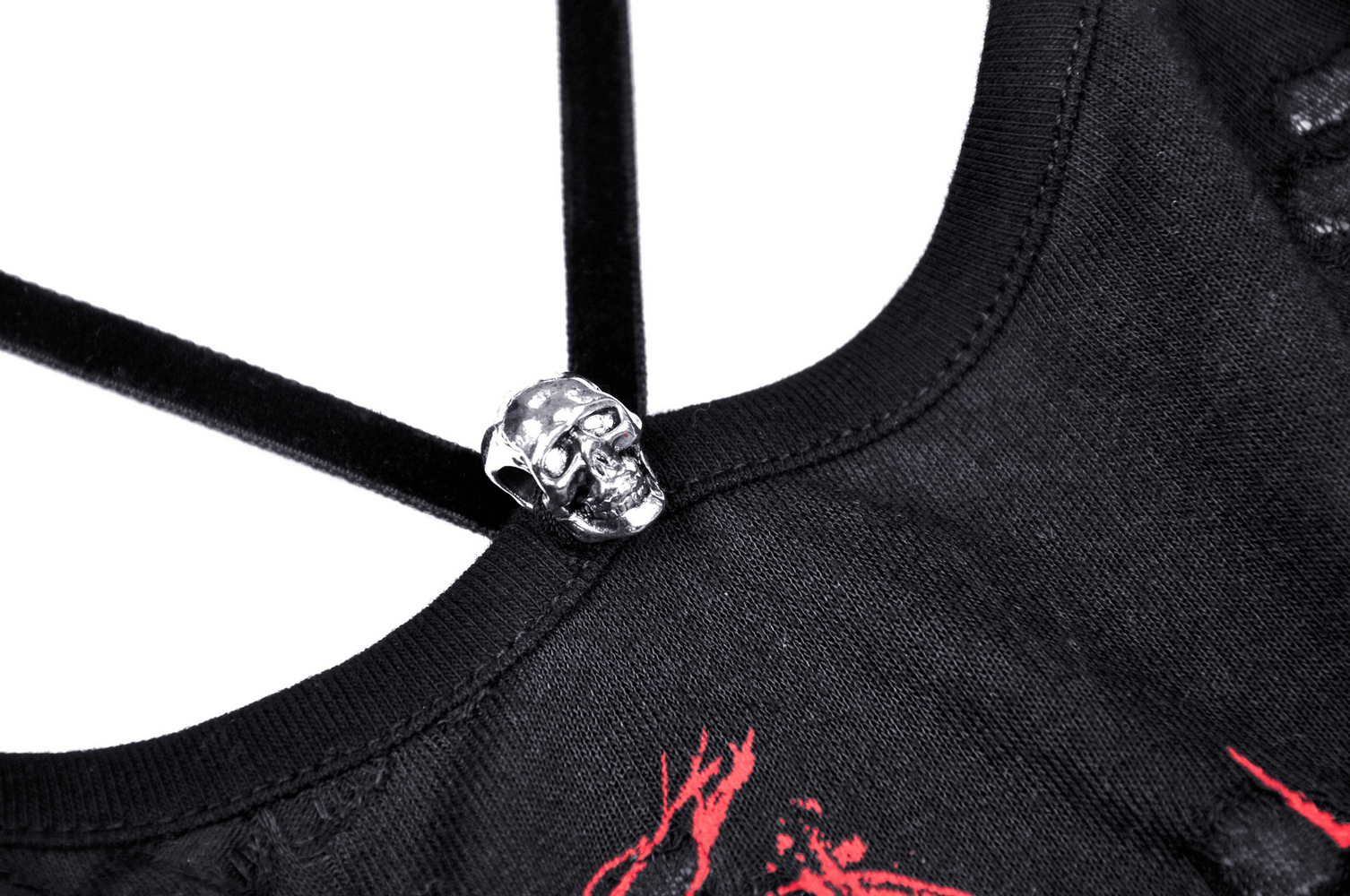 Close-up of edgy black crop top with red print and skull detail on strappy back design.