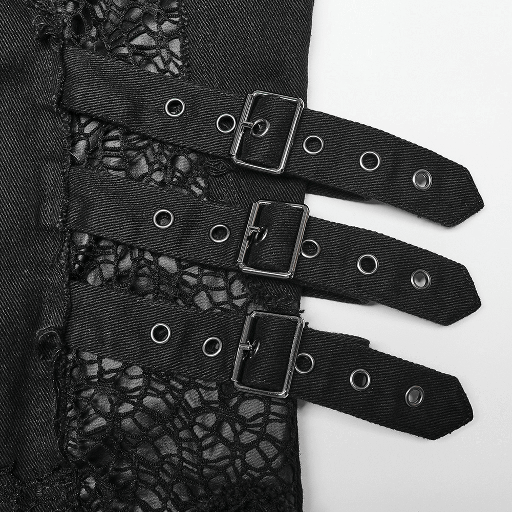 Close-up of edgy black trousers featuring buckles and mesh detailing, showcasing punk-inspired fashion.