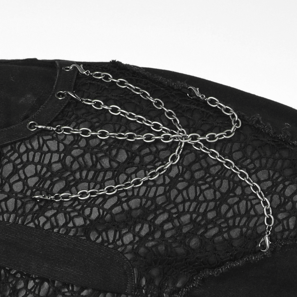 Close-up of edgy black trousers showcasing intricate mesh and chain detailing for a punk-inspired look.