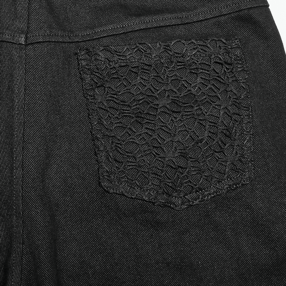 Close-up of textured black pocket detail on edgy gothic trousers with chains.