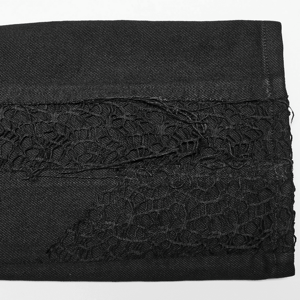 Close-up of edgy gothic black trousers with intricate mesh detailing and splicing design.