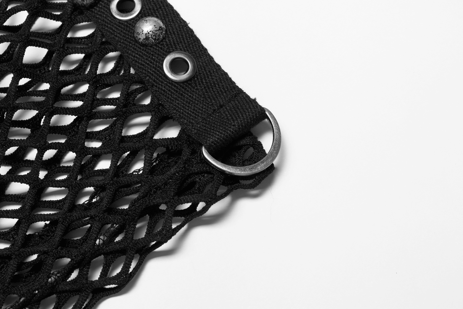 Close-up of black gothic mesh fabric with eyelets and a metal ring, perfect for edgy urban fashion.