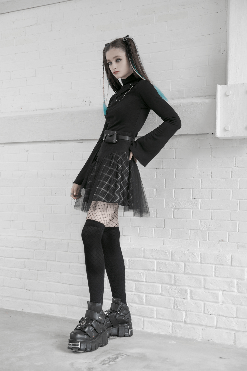 Edgy high-waist plaid and tulle punk mini skirt paired with a stylish black top and fishnet tights.