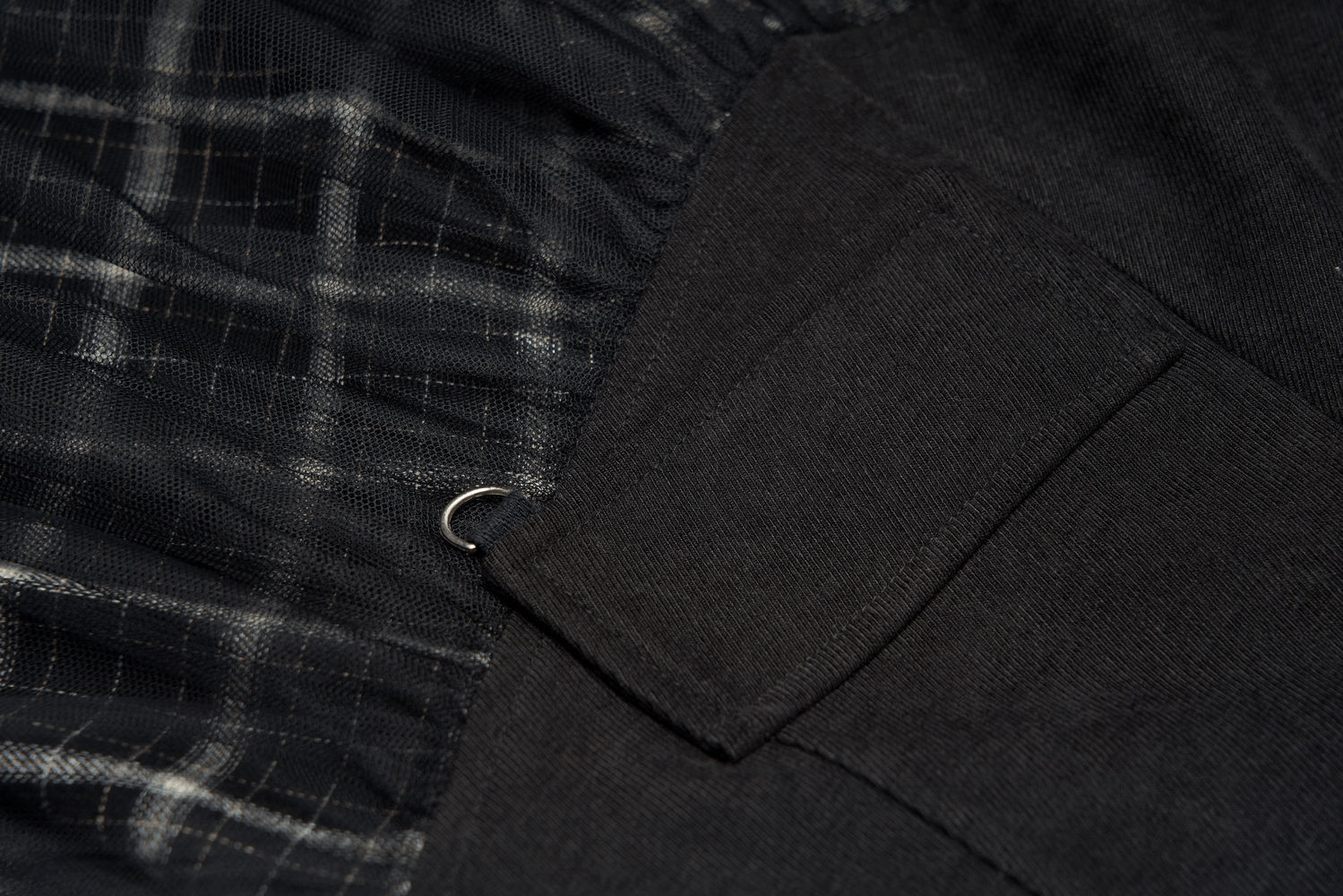 Close-up of the edgy high-waist plaid and tulle mini skirt showcasing the D-buckle detail and textured design.