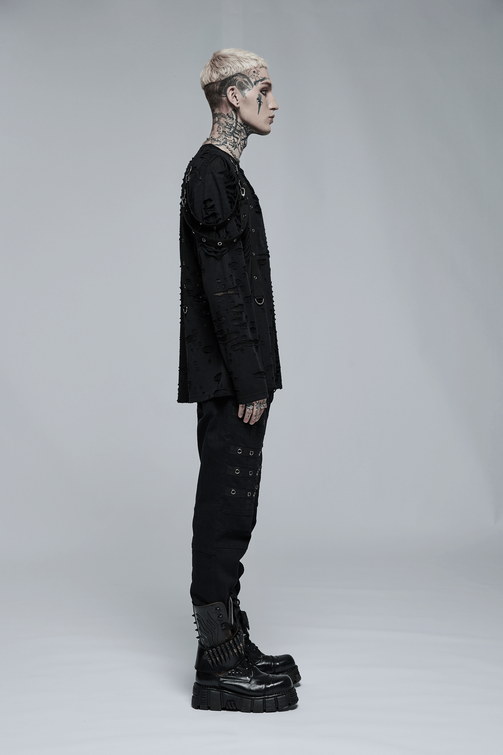 Side view of a model in an edgy black long sleeve top with destructed holes and loops, showcasing goth streetwear style.