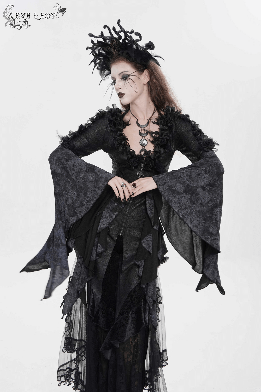 Model showcasing the Edgy Lace-Up Blouse with Rose Trim and Bell Sleeves, featuring dramatic flared sleeves and floral appliques.