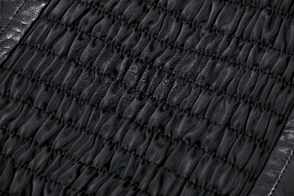 Close-up of the smocked panel on a black leather corset belt, showcasing its textured, flexible design for a punk aesthetic.