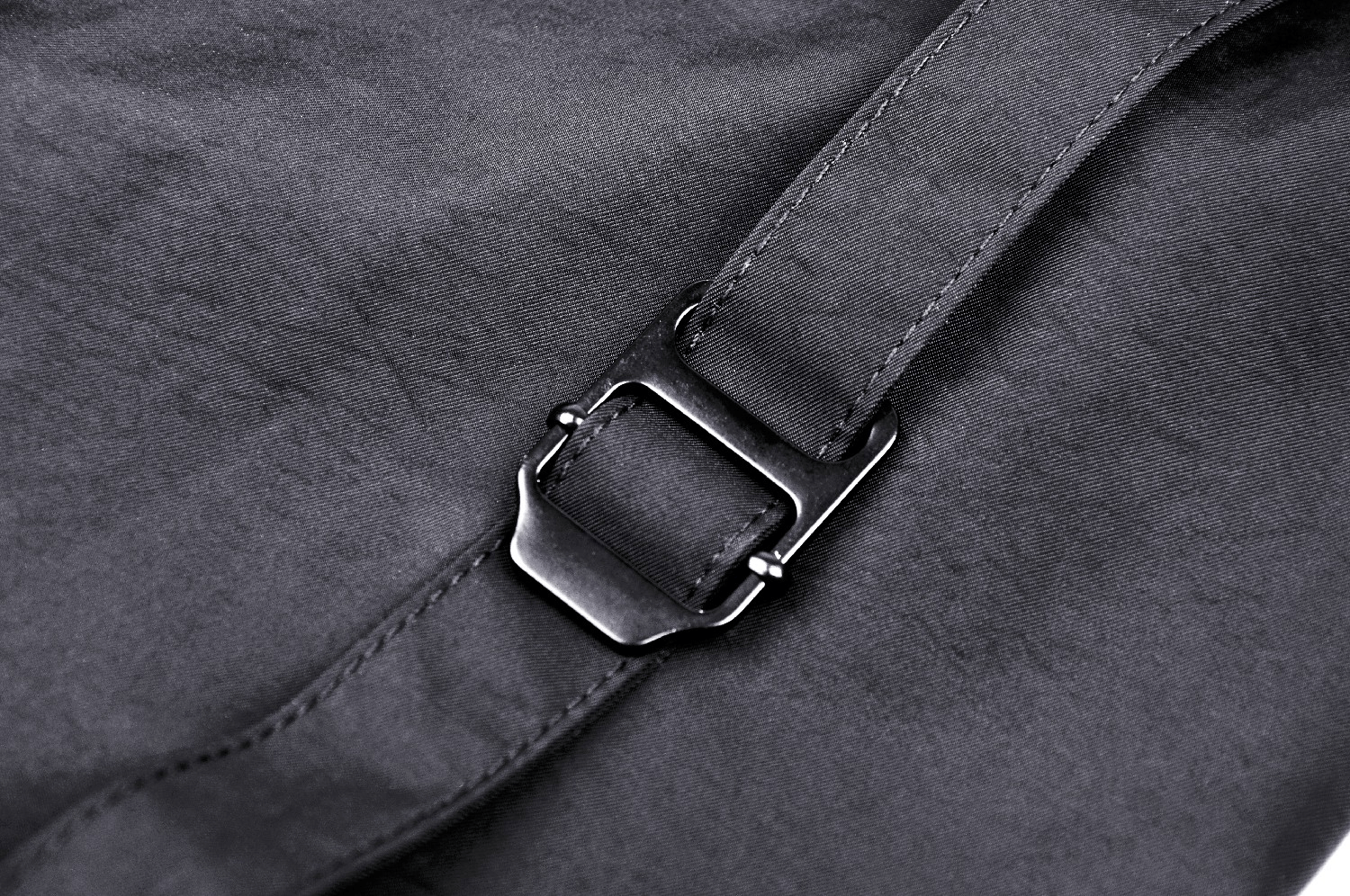 Close-up of a sleek black buckle on an edgy long sleeves cropped jacket.