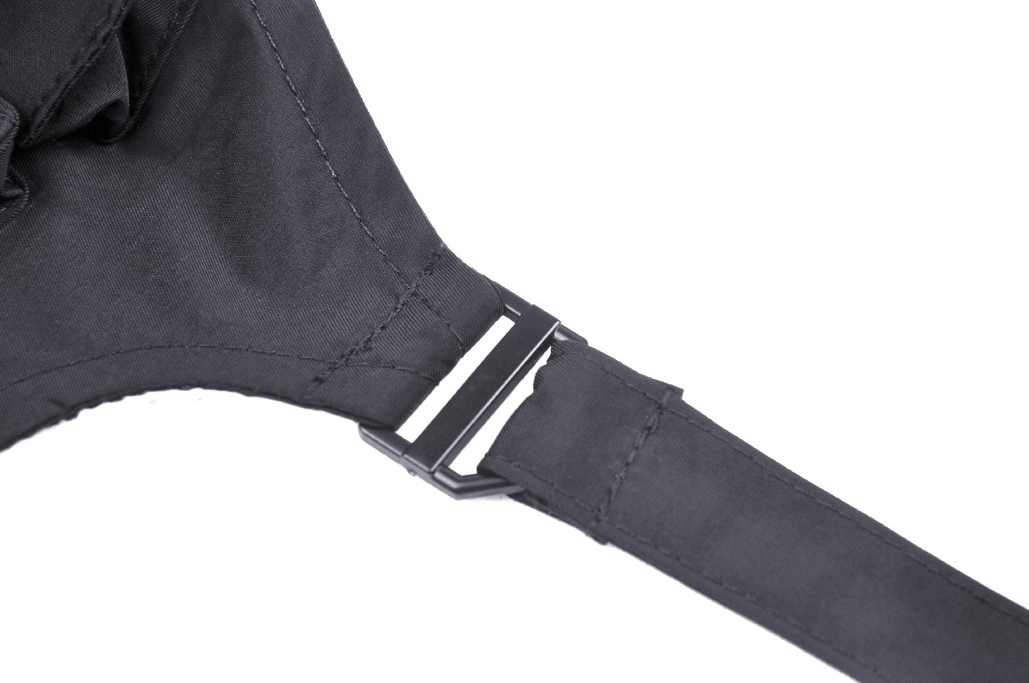 Close-up of a black cropped jacket strap with buckle detail, showcasing its edgy design and construction.